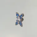 Close-up of a sparkling blue butterfly stud earring with clear reflections on a mirror surface. - 1 Piece (7mm*9mm)