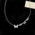 Dettaglio di una collana in argento con farfalla in madreperla e fiori di zirconi - Collana a Y Madreperla (R1743) / Argento