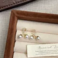 Detalle macro de elegantes pendientes dorados con perlas y acentos de circonita brillante - Pendientes de Botón de Perla Cereza (R0315)