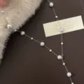 Elegant detail view of Y-shaped pearl necklace displayed on dark brown leather and faux fur - Y-Shaped Long Style (R1916) / Silver Manta Necklace