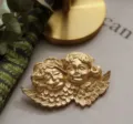 Gedetailleerd beeld van een vintage matgouden broche met twee cherubijnen en vleugels. - Tweeling Engelen (Stijl 5) / Mat Goud