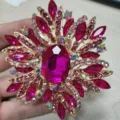 Elegante spilla dorata con cristalli fucsia e una grande pietra ovale centrale sfaccettata - Rosso rosa