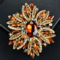 Elegante spilla vintage a raggiera con grandi cristalli arancio ambra e metallo dorato lucido - Marrone
