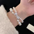 Close-up of a double-layer pearl bracelet with an elegant zircon bow detail. - R1378 Double Layer Bow Style