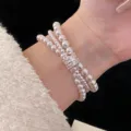 Close-up of triple-strand pearl bracelet with a sparkling zircon-inlaid clasp. - R1226 Triple Layer Pearl Style