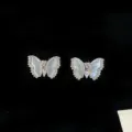 Dettaglio di eleganti orecchini a farfalla in conchiglia naturale con zirconi brillanti. - Orecchini a Bottone Farfalla in Madreperla (R2143) / Argento