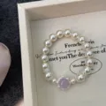 Close-up of pearl bracelet with purple amethyst center and silver hollow floral frame. - R2310 Purple Crystal Style