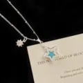Close-up of a silver star pendant necklace with micro-pave zircons and a blue center stone - Blue Star Necklace (R5470)