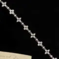 Detail view of silver-toned bracelet with clover motifs and zircon stones on black background. - Silver Four-Leaf Clover Style (R1364) / Length approx 16CM