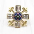 Macro detail of a vintage Baroque brooch in matte gold with enamel and shiny crystals - Baroque Cross Fleur-de-lis Brooch / Matte Gold (Main Image Style)