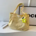 Yellow canvas tote bag, stylish daily shoulder bag with cute flower pendant variant. - Yellow