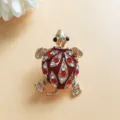 Detailed macro view of a vintage gold turtle brooch with red enamel and rhinestones - Vintage Turtle Style (U-5-2669) / Gold with Red
