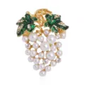 Close-up detail of fashion alloy grape brooch with white pearls and green leaves - White