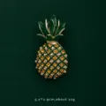 Macro view showing details of a pineapple brooch with yellow crystals and green enamel - Pineapple