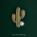 Detailed view of elegant cactus brooch with sparkling rhinestones and a large pearl - Cactus