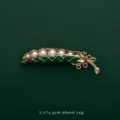 Close-up view of a vintage pea pod brooch featuring white pearls and green enamel - Pea Pod