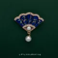 Detailed view of fan-shaped blue enamel brooch with bamboo pattern and pearls - Fan