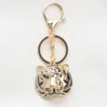 Golden alloy tiger head keychain with sparkling rhinestones and black enamel details - Gold