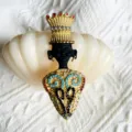 Vue détaillée d'une broche de chef de tribu vintage avec couronne et strass colorés - Style Chef Doré