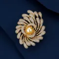 Macro detail of luxury golden fireworks brooch with shimmering crystals and gold pearl - Gold Firework Golden Pearl