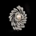 Close-up of a luxurious silver-tone firework brooch with sparkling crystals and central pearl. - Silver Firework White Pearl