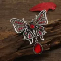 Elegant vintage silver butterfly brooch featuring red rhinestones and waterdrop pendant - Red