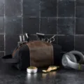 Detail view of a men's vintage canvas and leather dopp kit with grooming accessories - Black