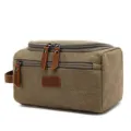 Detail view of a durable khaki canvas travel toiletry bag with leather pulls - Khaki