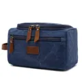 Detail view of the durable blue canvas fabric and faux leather zipper pulls on the travel bag. - Dark Blue