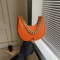 Trendy orange felt crescent underarm bag featuring a chunky gold chain handle for women - Orange