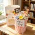 Detail view of handmade ceramic flower bouquet gift with pink tulle ribbon and gift bag. - Pink