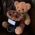 Plush teddy bear holding a romantic rose bouquet, perfect Valentine gift for her special day. - Mocha with Tote Bag & String Lights