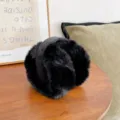 Soft black plush earmuffs for winter warmth on a wooden table lifestyle setting. - Foldable Style (WHEZ002-B) / Black