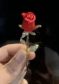Elegantes Detail einer roten Rosenbrosche mit funkelnden, kristallbesetzten Blättern. - Gold Rot Emaille Rose