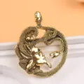 Primo piano di una spilla Medusa dorata vintage con dettagli di serpenti molto fini - Oro