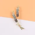 Detailed macro shot of an elegant gold-toned wheat ear brooch with blue gradient crystals. - Blue