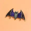 Detailed view of the blue rhinestone encrusted bat brooch with gold-toned finish - Gold Bat Style (Brooch 1) / Gold Base Dark Light Blue Rhinestone Style (Brooch 1)