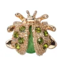 Exquisite golden ladybug brooch featuring sparkling green crystals and textured stone inlay. - Green Rhinestone Style