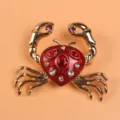 Detailed view of a gold-toned crab brooch with red enamel and sparkling rhinestones. - Crab Style (O5-1-5374)