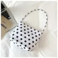 Primer plano detallado de un elegante bolso de hombro blanco con lunares negros - Blanco