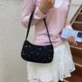 Detalle de un dulce bolso de hombro negro con patrón de estrellas blancas. - Negro
