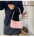 Primer plano de un bolso de hombro rosa con patrones de estrellas plateadas sostenido por una modelo. - Rosa