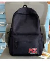 Vue détaillée d'un sac à dos d'écolier noir avec logo brodé MZ Lucky sur une chaise - Noir