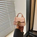 Handheld micro mini pink crossbody bag charm featuring a gold metallic lock and chain strap - Pink