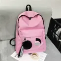 Stilvoller rosa Canvas-Rucksack mit schwarzem Bommel-Anhänger im modernen Akademie-Stil - Rosa