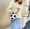 Detailansicht der Handtasche in Fußballform mit goldener Kette, getragen von einem Modell. - Fußballform / Schwarz Weiß