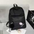 Minimalistischer schwarzer Canvas-Rucksack für Schüler mit Bommel-Schlüsselanhänger. - Schwarz