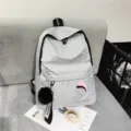 Minimalistischer grauer Canvas-Schulrucksack mit Pom-Pom-Anhänger für Damen und Herren - Hellgrau