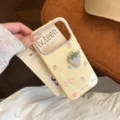 Détail d'une coque iPhone crème avec une fraise brodée en 3D et des motifs pastel doux - Jaune Mangue (Fraise en Tissu Violet 3D) / iPhone 17 Pro Max
