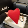 Elegante monedero rojo con forma de corazón, correa de muñeca colorida y textura de cuero - Rojo